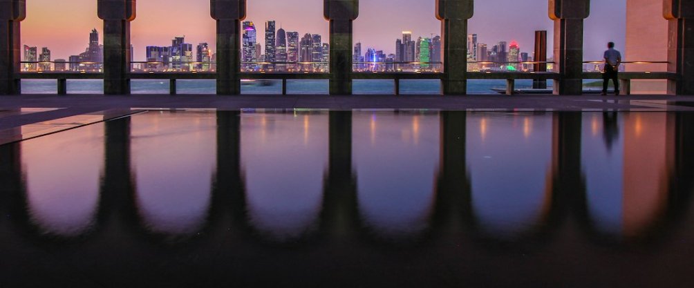 Formula 1 cars racing under the lights at Lusail International Circuit in Qatar